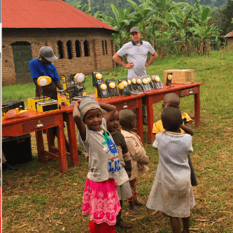 Go Solar Group CEO, Keven Jensen, with children in Uganda
